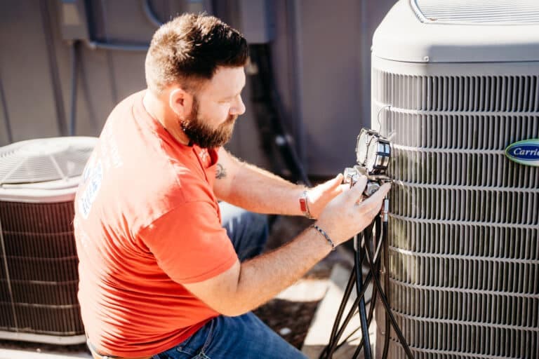 Technician inspecting residential air-conditioning equipment